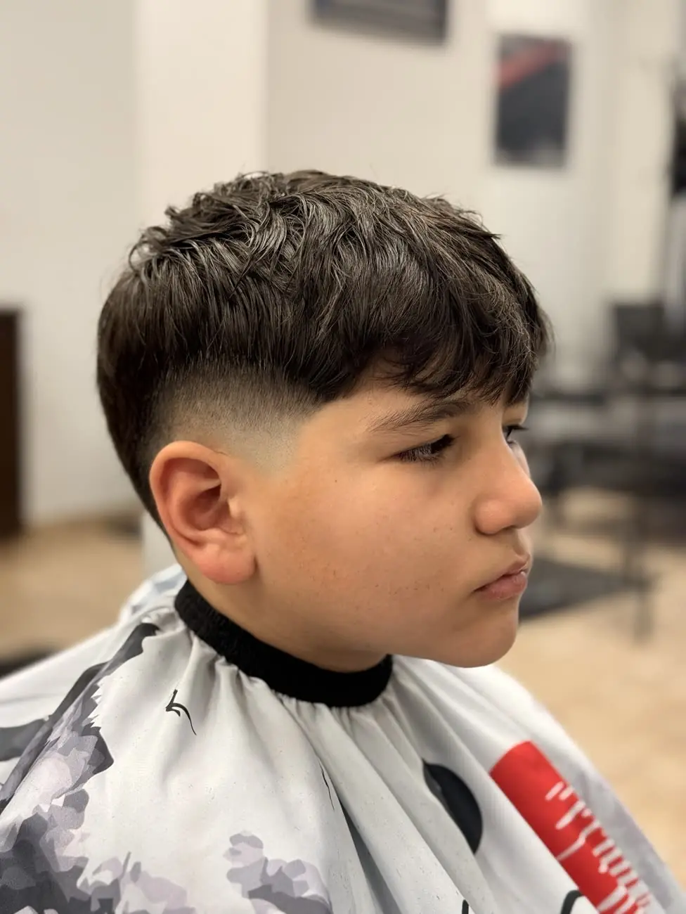 Young client with a textured fringe and a low fade